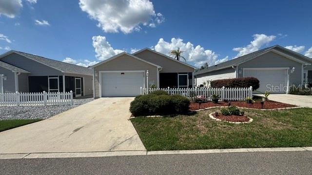 A row of three single-story suburban houses with white picket fences and concrete driveways — 2029 FAIRVIEW LANE, THE VILLAGES, FL