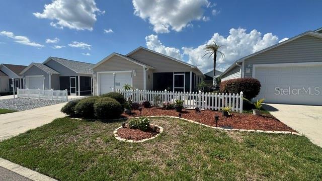 A suburban house with a white picket fence and a landscaped front yard — 2029 FAIRVIEW LANE, THE VILLAGES, FL