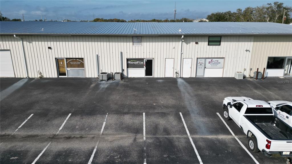 An exterior view of a commercial building with multiple business entrances and a parking lot — 23375 JANICE AVENUE UNIT 12, PUNTA GORDA, FL