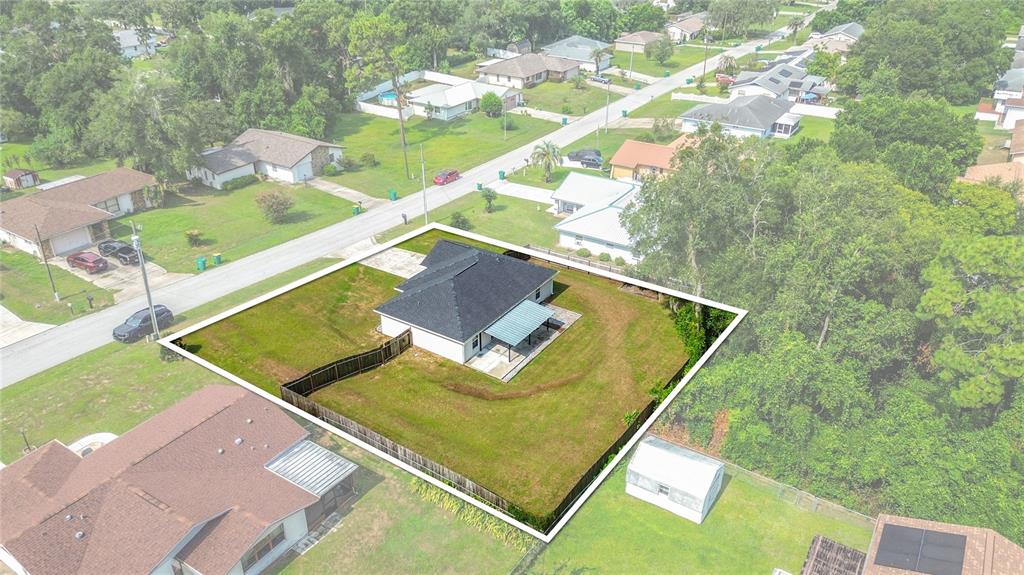 An aerial view shows a single-story house with a fenced backyard in a residential neighborhood — 312 CLARK STREET, INVERNESS, FL