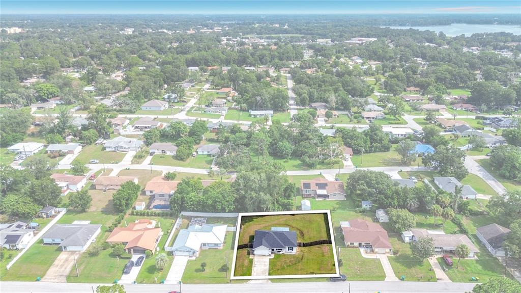 An aerial view shows a single-story house with a fenced yard in a suburban neighborhood — 312 CLARK STREET, INVERNESS, FL