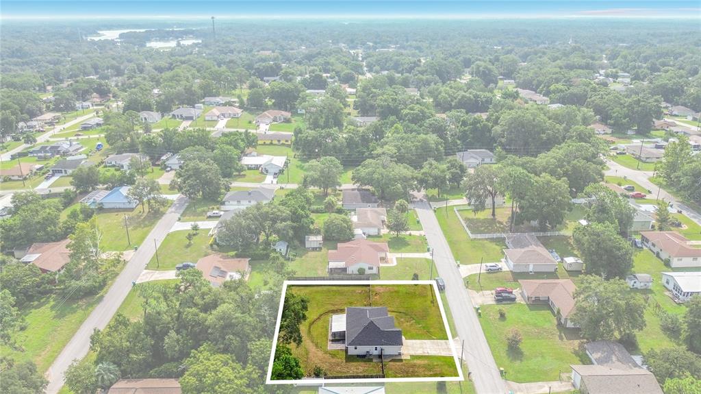 An aerial view shows a single-story house with a dark roof on a grassy lot — 312 CLARK STREET, INVERNESS, FL