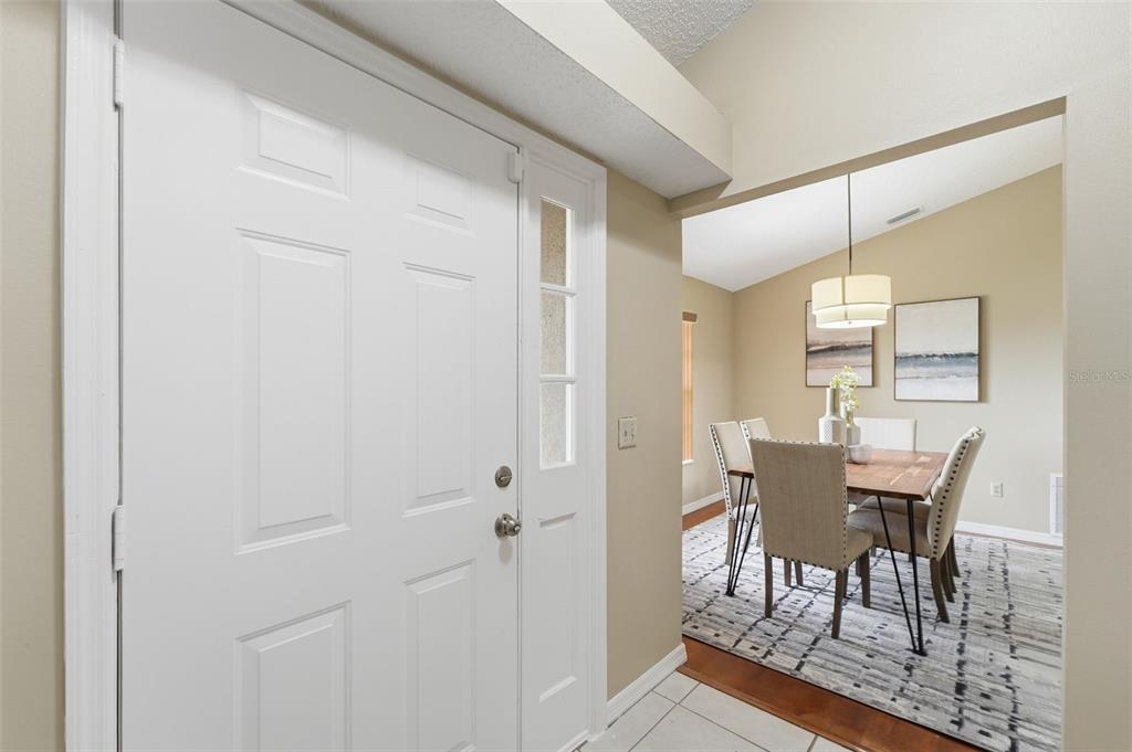 A white front door opens into a dining area with a table and chairs — 20753 MAXIM PARKWAY, ORLANDO, FL