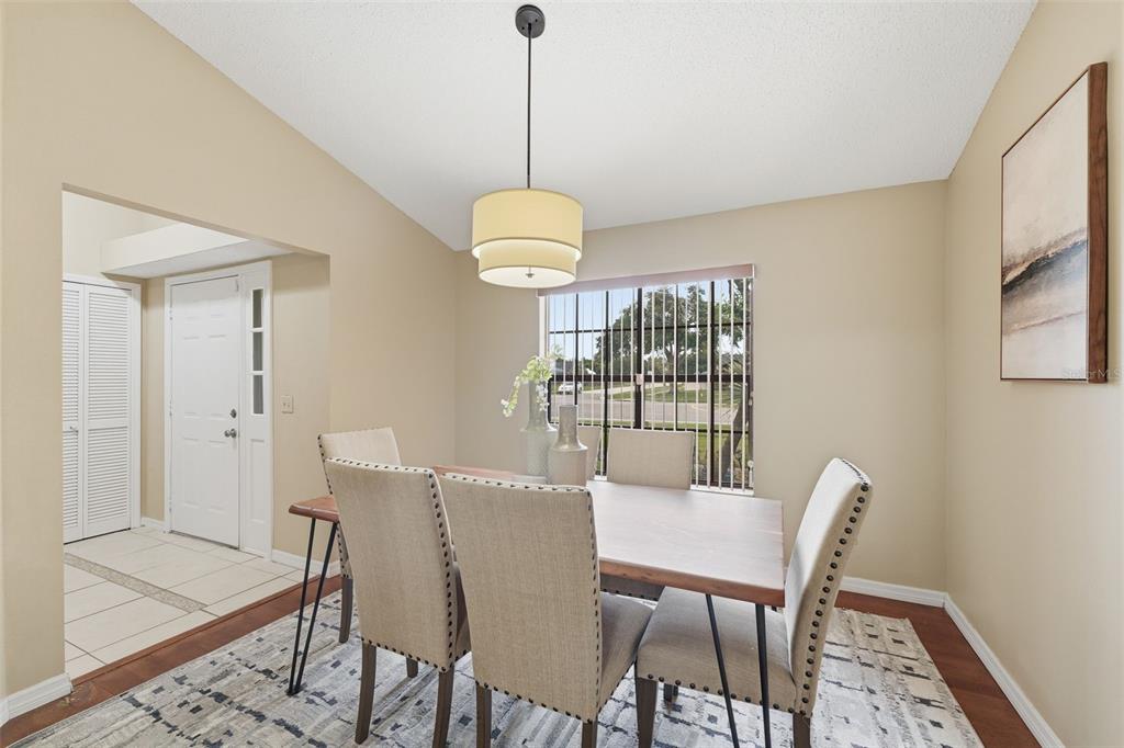 A dining room features a wooden table, upholstered chairs, a pendant light, and a window — 20753 MAXIM PARKWAY, ORLANDO, FL