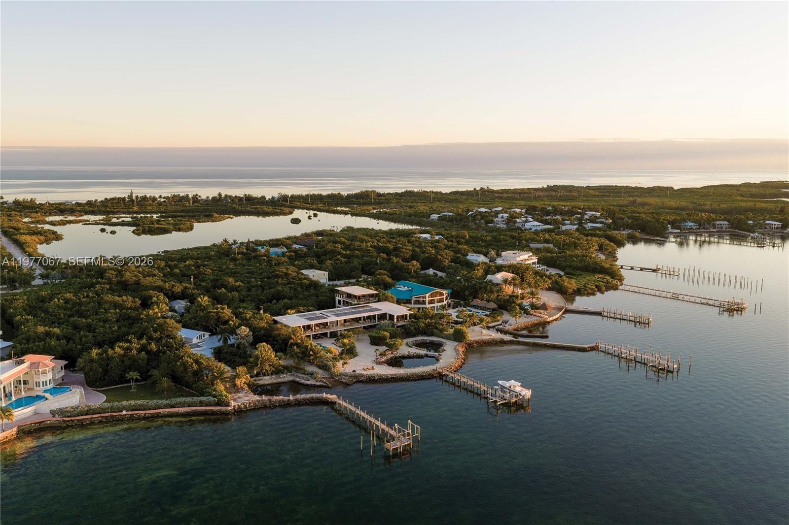 An aerial view shows waterfront homes with private docks and pools surrounded by lush vegetation — 57783 Morton Street, Marathon FL 33050, MARATHON, FL