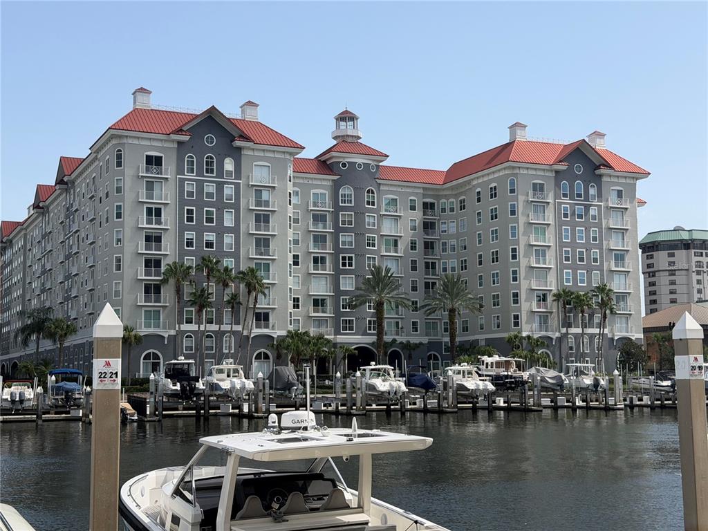 A multi-story building with a red roof stands behind a marina filled with boats — 700 S HARBOUR ISLAND BOULEVARD UNIT 512, TAMPA, FL