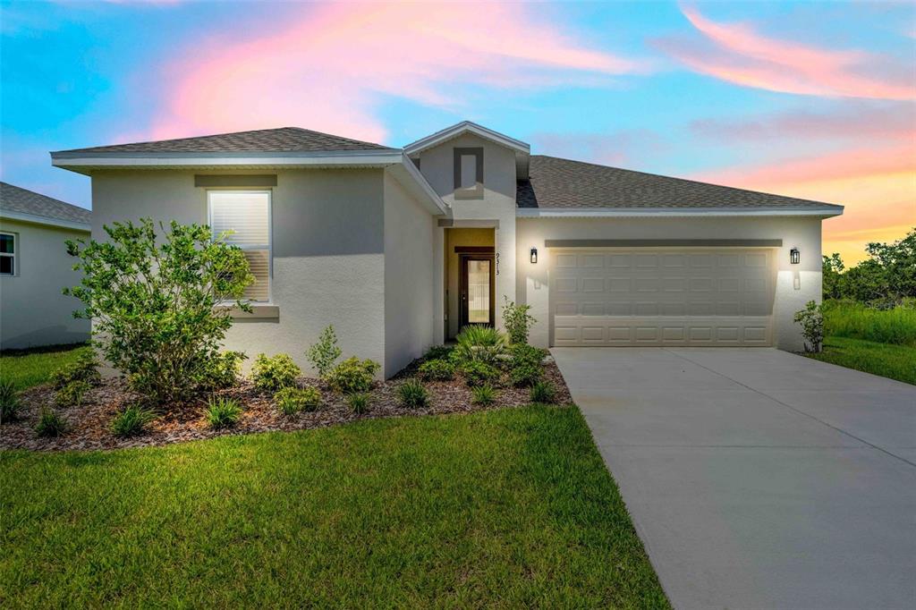 A single-story house with a beige stucco exterior, a two-car garage, and a concrete driveway — 9313 GENTLE BEN COURT, WEEKI WACHEE, FL