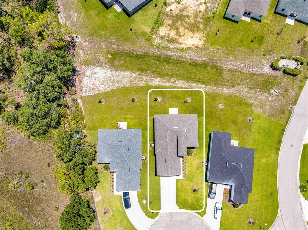 An aerial view shows a single-family house with a white outline on its property lot — 9313 GENTLE BEN COURT, WEEKI WACHEE, FL