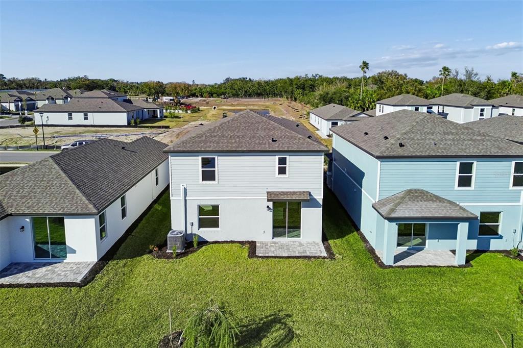 An aerial view shows the rear exterior of three suburban houses with small paved patios — 4311 OUTHAUL RUN, PALMETTO, FL