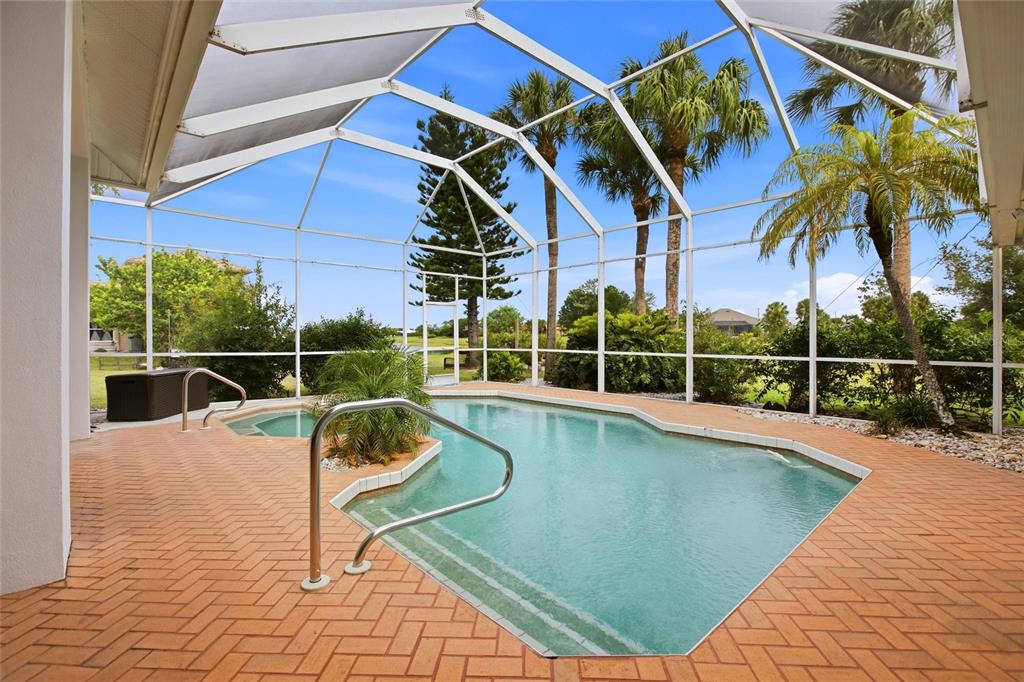 A screened-in patio features a swimming pool, a hot tub, and brick pavers — 1241 NEAPOLITAN ROAD, PUNTA GORDA, FL