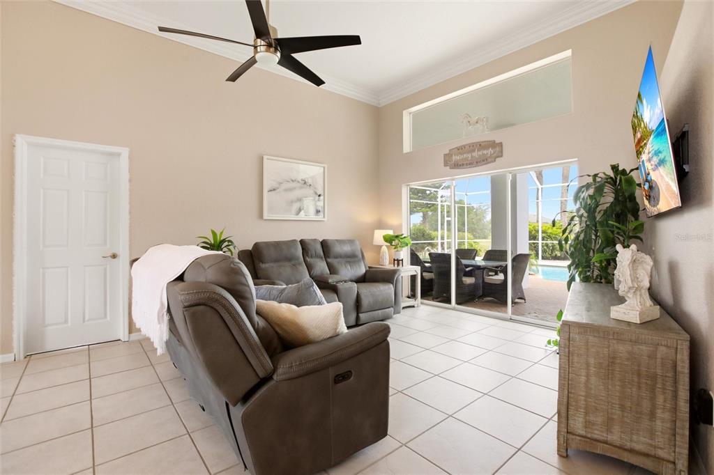 A living room with tile floors, a ceiling fan, and sliding doors opening to a pool — 1241 NEAPOLITAN ROAD, PUNTA GORDA, FL