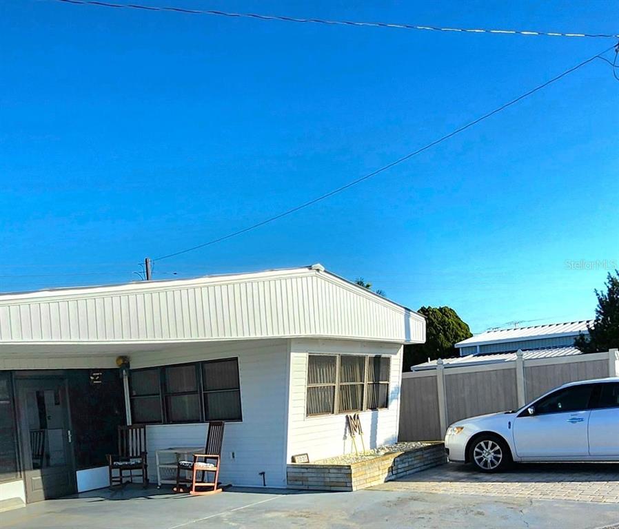 A white mobile home with a carport and a white car parked in the driveway — 2003 MINNESOTA AVENUE, BRADENTON, FL
