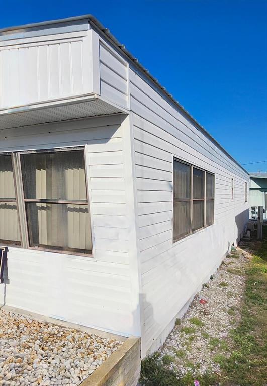 The exterior of a white mobile home features horizontal siding and several rectangular windows — 2003 MINNESOTA AVENUE, BRADENTON, FL
