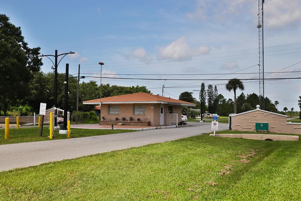 A gated community entrance features a small tan building with a tile roof and landscaping — 0 OLEANDER DRIVE, INDIAN LAKE ESTATES, FL