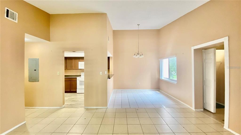 An open-concept dining area with tile flooring, a chandelier, and a view into the kitchen — 2528 CITRUS CLUB LANE UNIT 206, ORLANDO, FL