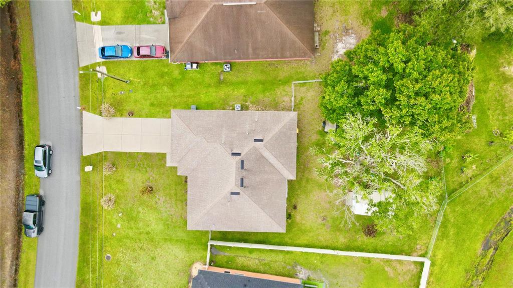An aerial view shows a house with a driveway, a large tree, and parked cars — 535 GULL DRIVE, KISSIMMEE, FL