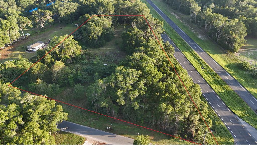 An aerial view shows a triangular plot of land bordered by a road and highway — 2303 NW 145TH STREET, CITRA, FL