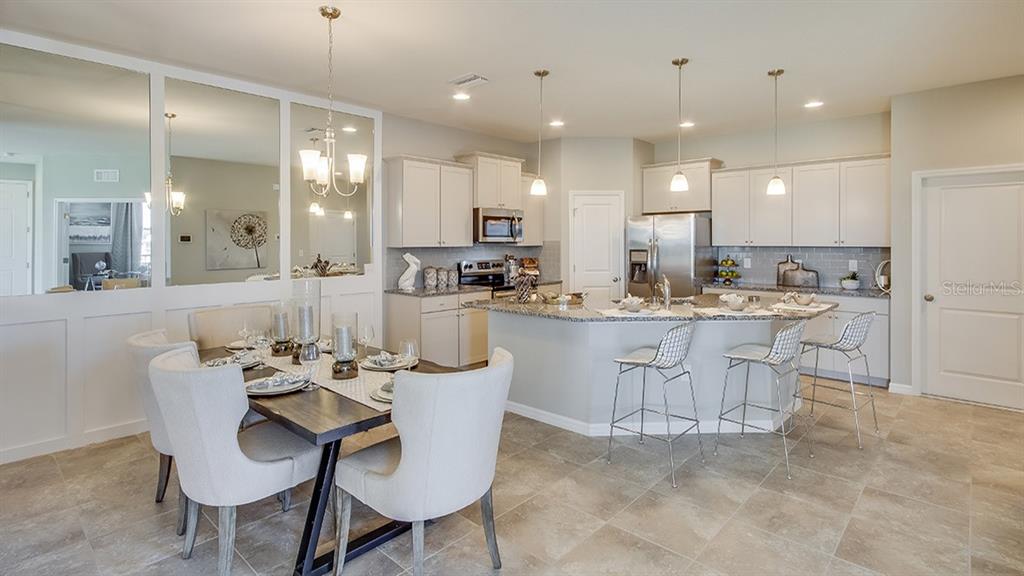 A kitchen and dining area with light cabinetry, granite countertops, and tile flooring — 4749 NW 39TH STREET ROAD, OCALA, FL
