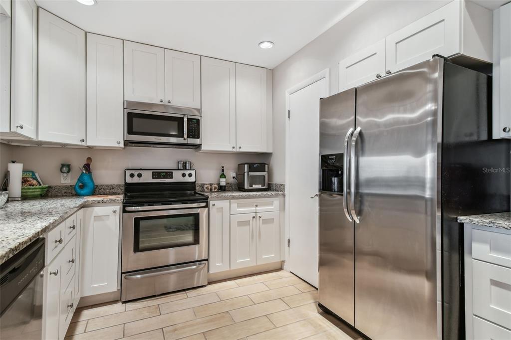 A kitchen with white cabinets, stainless steel appliances, and granite countertops — 301 MARINER DRIVE UNIT 301, TARPON SPRINGS, FL