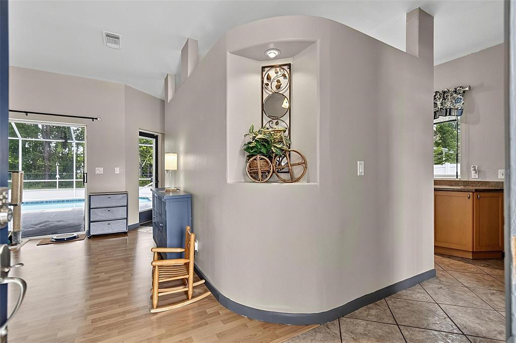 A curved wall with a recessed niche separates a living area from a kitchen — 14 WILLS PLACE, PALM COAST, FL