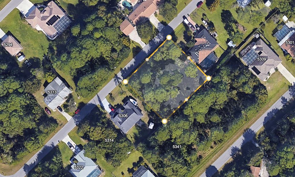 This aerial map shows a vacant, tree-covered residential lot highlighted by yellow corner markers — 5290 JOHNSON TERRACE, PORT CHARLOTTE, FL