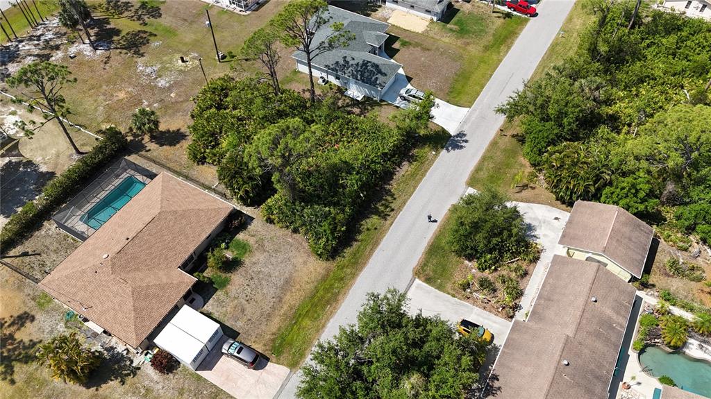 An aerial view shows two houses with swimming pools and driveways along a paved road — 5290 JOHNSON TERRACE, PORT CHARLOTTE, FL