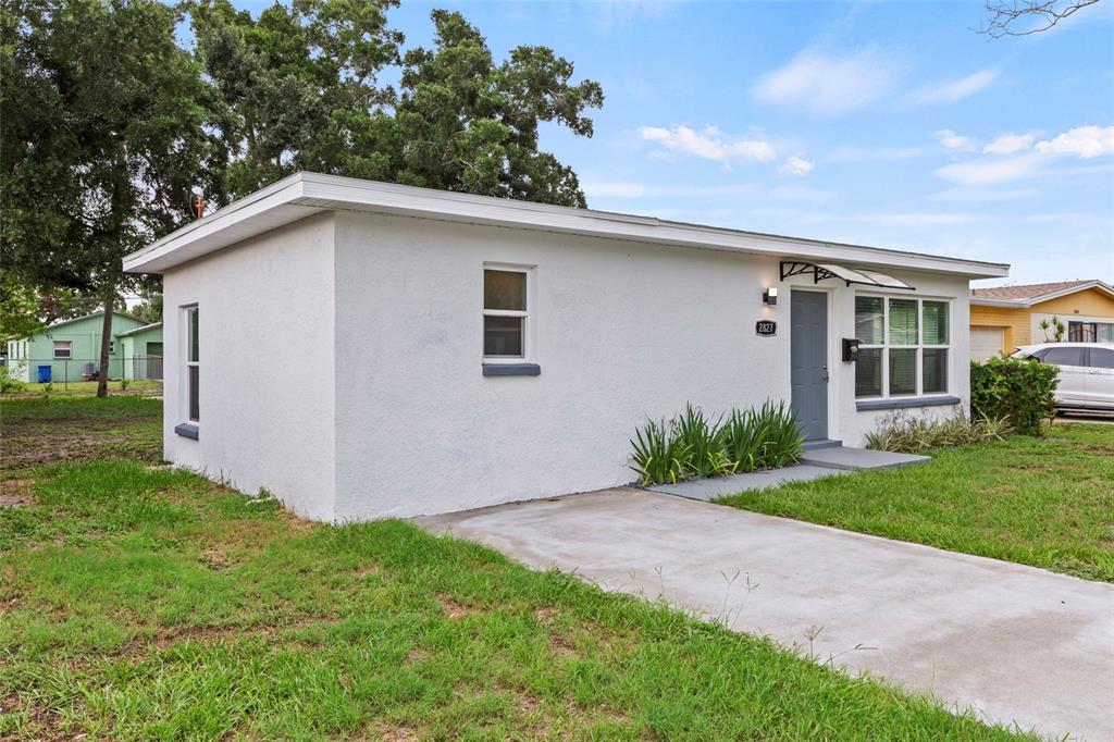 A white, single-story house with a flat roof, a concrete driveway, and a front door — 2827 16TH AVENUE S, ST PETERSBURG, FL