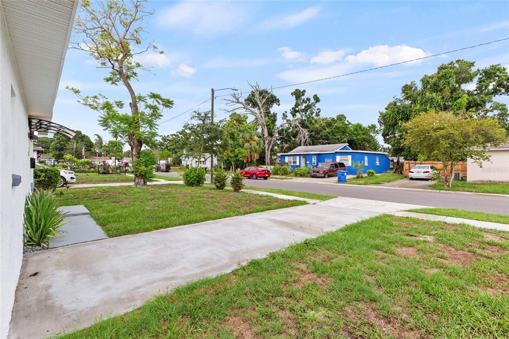 A view from a concrete driveway looking toward a street with houses and trees — 2827 16TH AVENUE S, ST PETERSBURG, FL