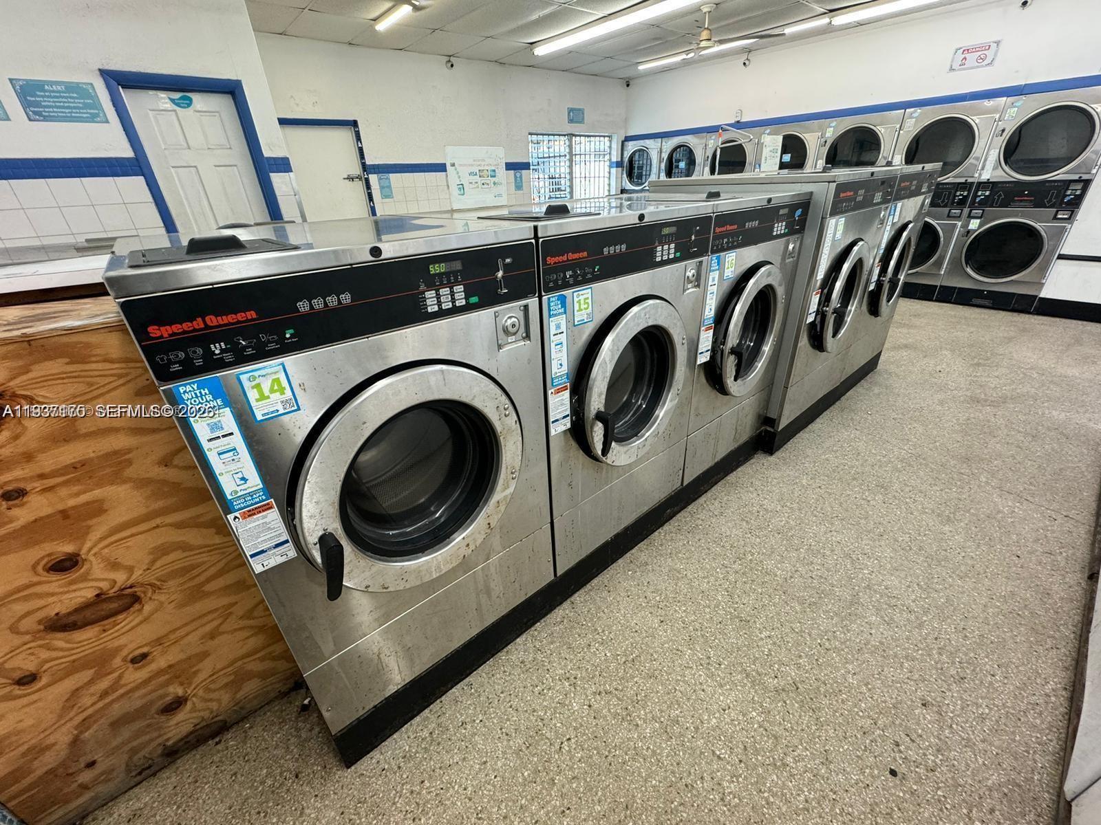 A row of stainless steel Speed Queen commercial dryers lines a laundry room with tile floors — Laundromat Hallandale Beach, Hallandale Beach FL 33009, HALLANDALE BEACH, FL