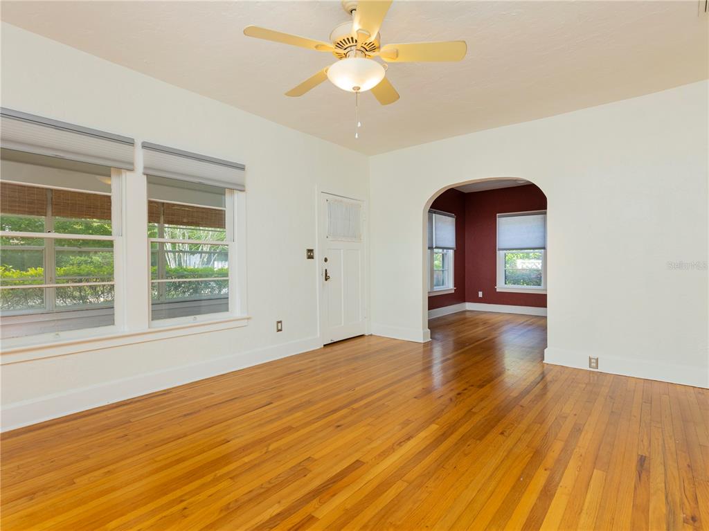 A living room with hardwood floors, a ceiling fan, and an arched doorway — 501 NE 8TH AVENUE, GAINESVILLE, FL