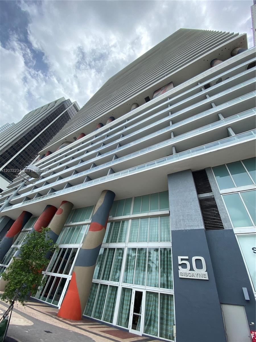 A low-angle exterior view of a modern high-rise building with a prominent 50 Biscayne sign — 50 Biscayne Blvd # 2902, Miami FL 33132, MIAMI, FL