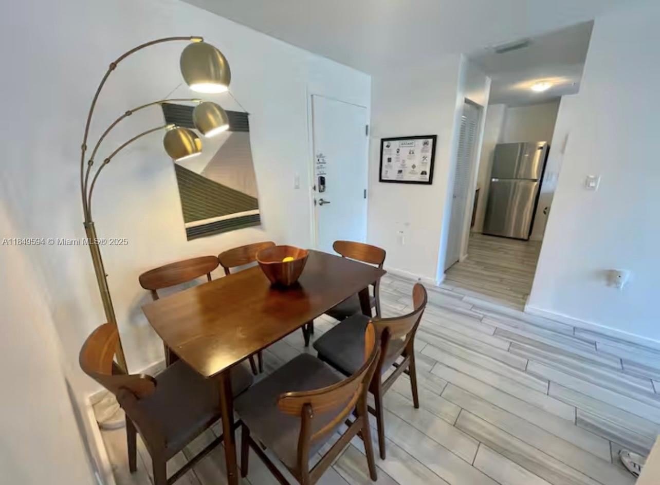 A dining area features a wooden table, six chairs, and a floor lamp — 481 NE 29th St # 705, Miami FL 33137, MIAMI, FL