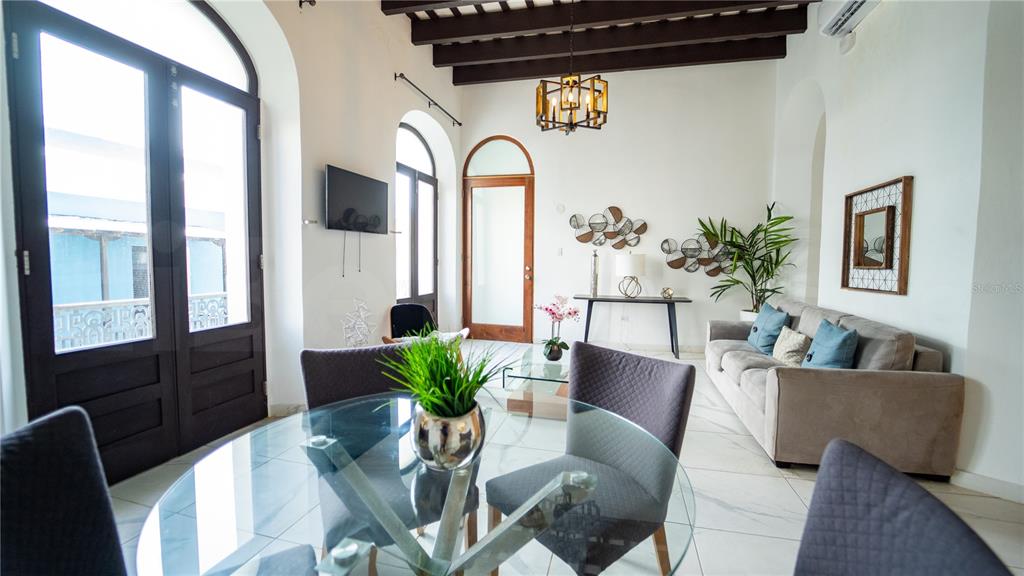 A living and dining area features white walls, tile floors, and exposed dark wood beams — 101 SOL STREET UNIT 2B, OLD SAN JUAN, PR