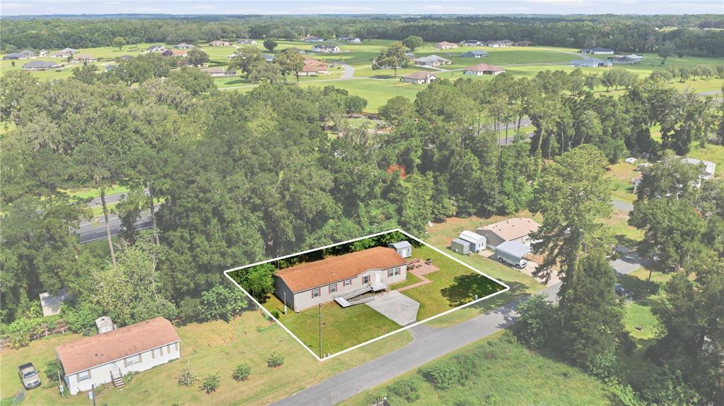 An aerial view shows a single-story house with a brown roof and a concrete driveway — 8450 NW 15TH AVENUE, OCALA, FL