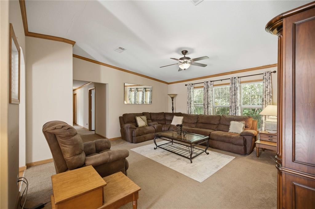 A living room features a brown sectional sofa, a recliner, and a glass-top coffee table — 8450 NW 15TH AVENUE, OCALA, FL
