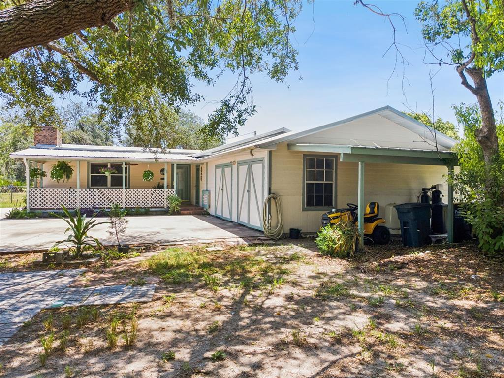 A single-story house with a white lattice porch, a carport, and a concrete driveway — 8681 DEER RUN DRIVE, LAKE WALES, FL