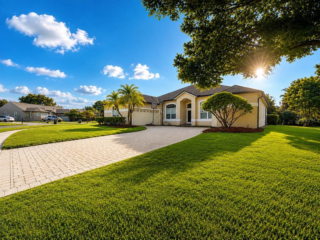 A single-story house with a paved driveway, palm trees, and a green lawn — 4419 SADDLEWORTH CIRCLE, ORLANDO, FL