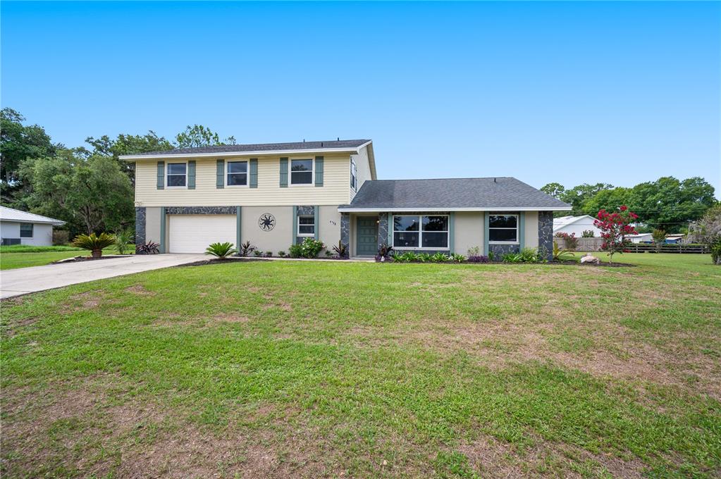 A two-story house with a beige exterior, a garage, and a large front lawn — 4128 MATHER ROAD W, LAKELAND, FL