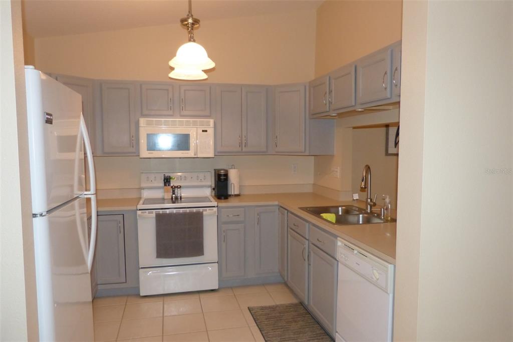 A kitchen with light gray cabinets, white appliances, and a beige countertop — 1610 SEASCAPE CIRCLE UNIT 1610, TARPON SPRINGS, FL