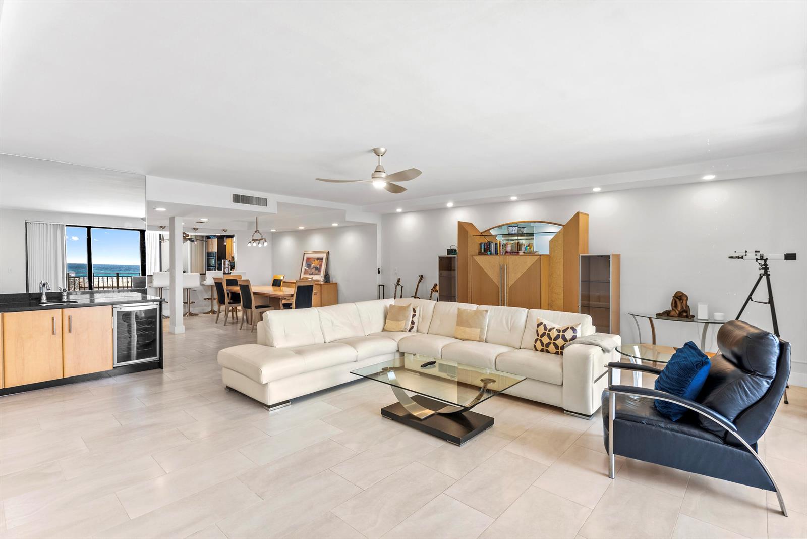 A spacious living room features a white sectional sofa, glass coffee table, and ocean view — 2155 S Ocean Boulevard # 11, Delray Beach FL 33483, DELRAY BEACH, FL