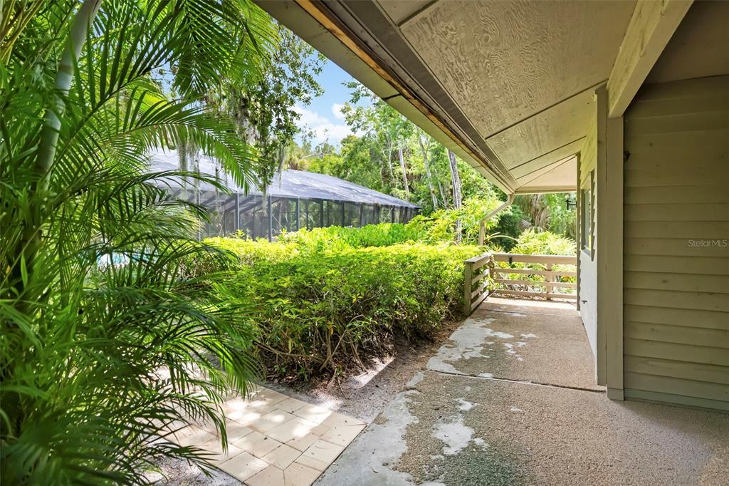 A covered patio features a wood-paneled ceiling, a ceiling fan, sliding glass doors, and a door — 5182 LANCEWOOD DRIVE UNIT 14, SARASOTA, FL