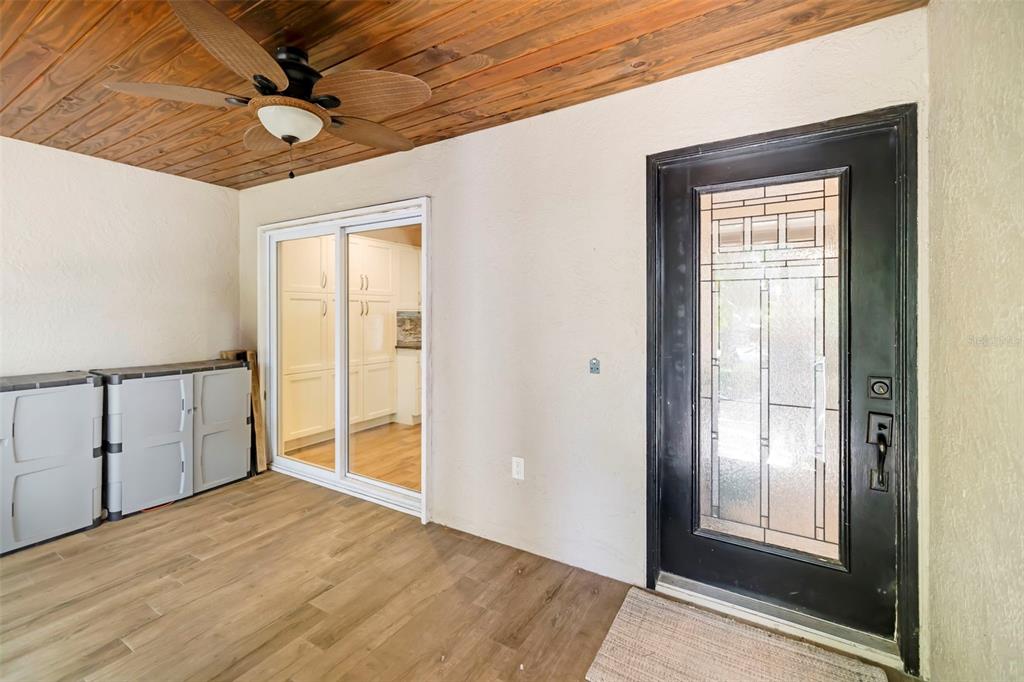 A living room features wood-look flooring, a stone fireplace, vaulted ceilings with skylights, and furniture — 5182 LANCEWOOD DRIVE UNIT 14, SARASOTA, FL