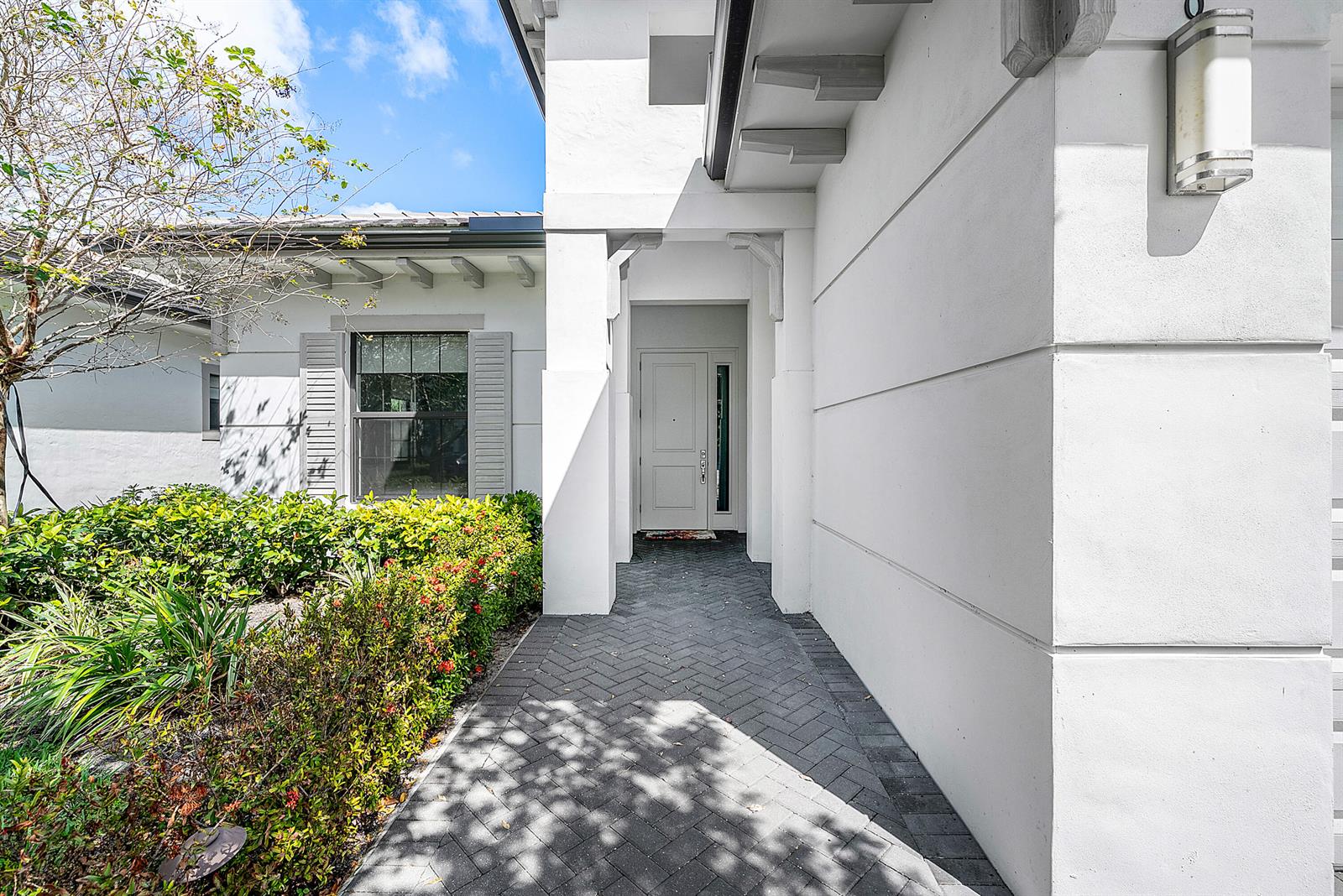 A paved walkway leads to the white front entrance of a modern stucco home — 3069 Safflower Circle, West Palm Beach FL 33401, WEST PALM BEACH, FL