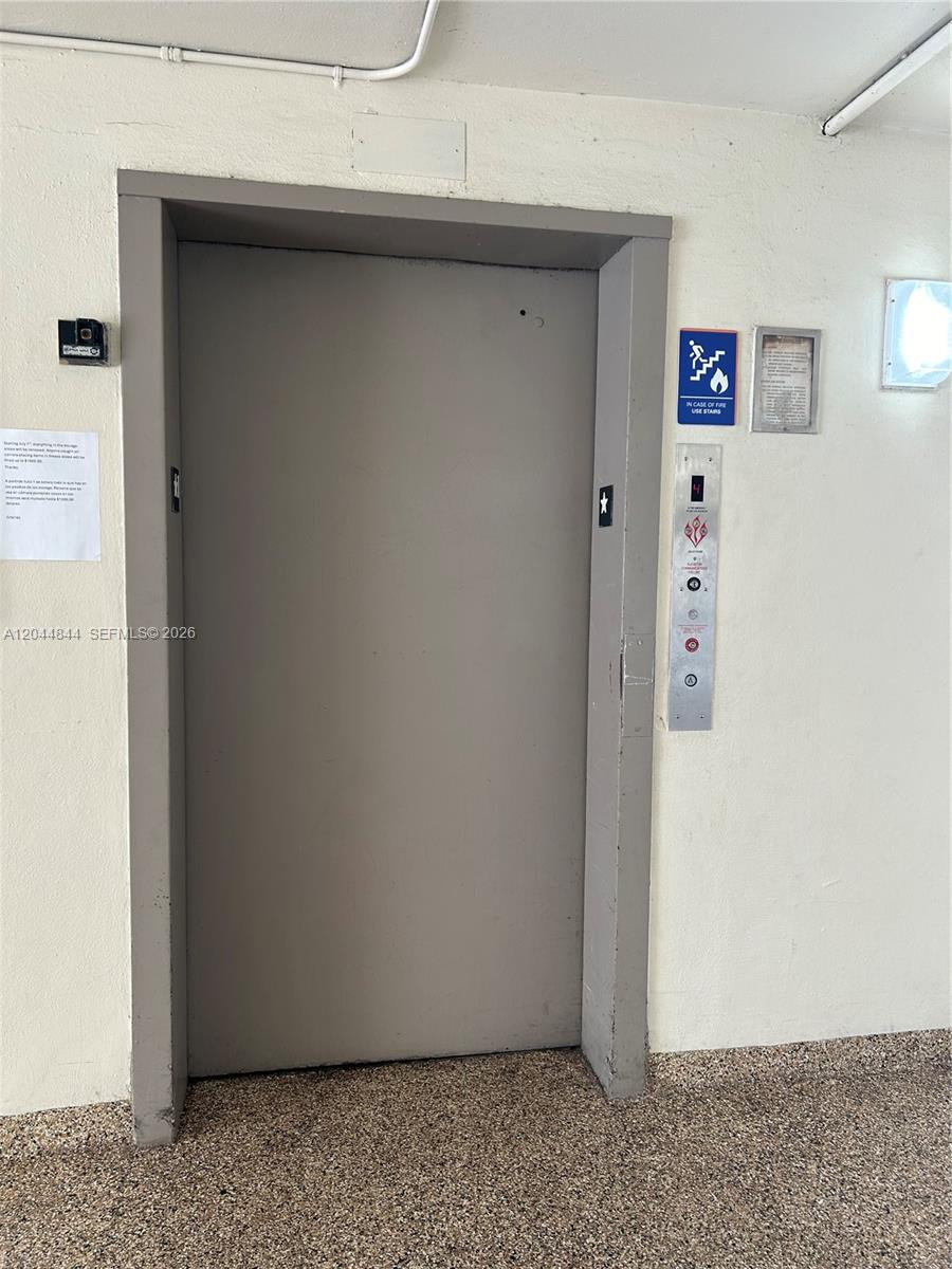 A gray elevator door is set into a plain wall with a floor indicator panel — MIAMI, FL