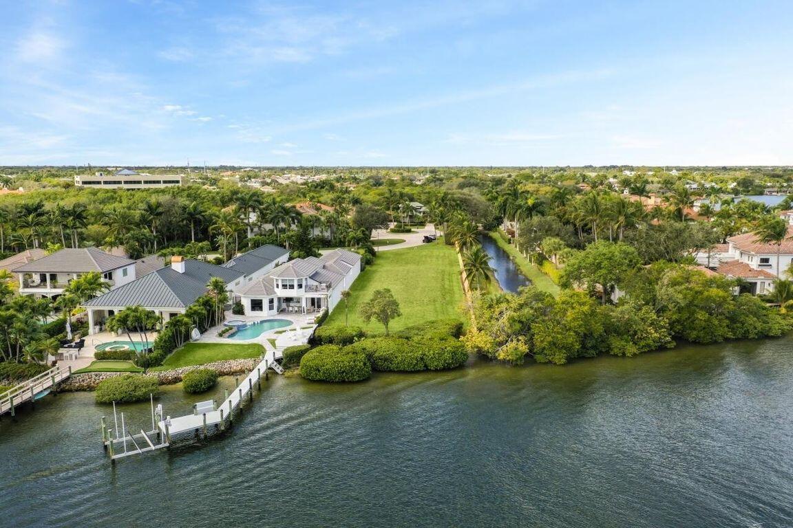 An aerial view of a waterfront house with a pool, dock, and large grassy lawn — 0 Fishermans Way, Jupiter FL 33477, JUPITER, FL