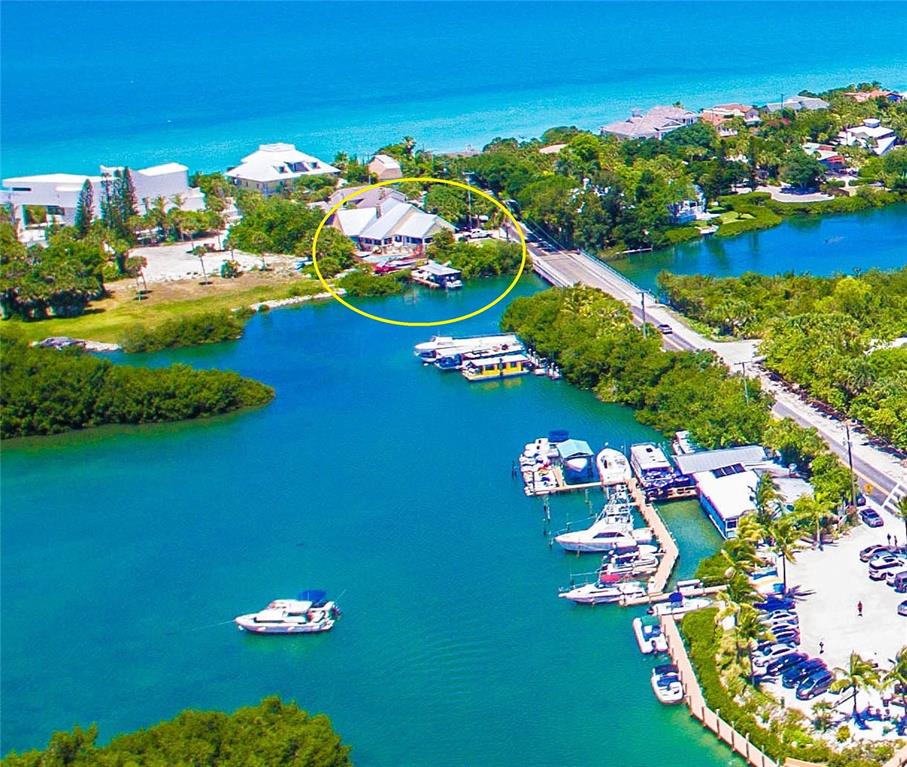An aerial view shows a waterfront house with a private dock near a bridge — 4024 CASEY KEY ROAD, NOKOMIS, FL