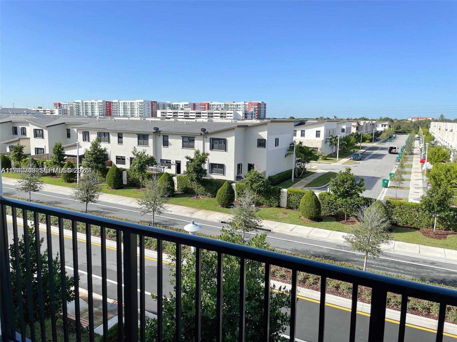 An elevated view shows a suburban street with townhouses, manicured landscaping, and a clear sky — 8151 NW 104th Ave # 34, Doral FL 33178, DORAL, FL