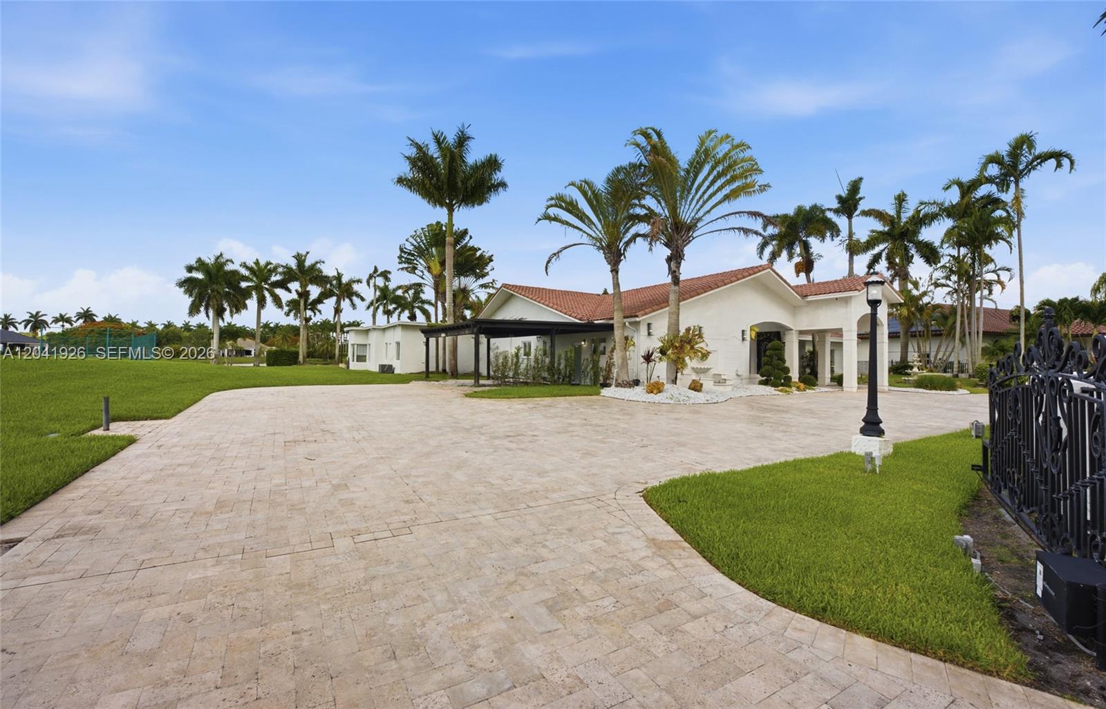 A white house with a tile roof and a large paved driveway surrounded by palms — 16170 Saddle Ln, Weston FL 33326, WESTON, FL
