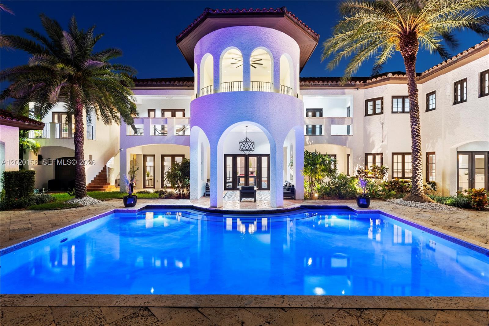 A large white Mediterranean-style house with a central tower overlooks a lit swimming pool — 1201 NE 83rd St, Miami FL 33138, MIAMI, FL