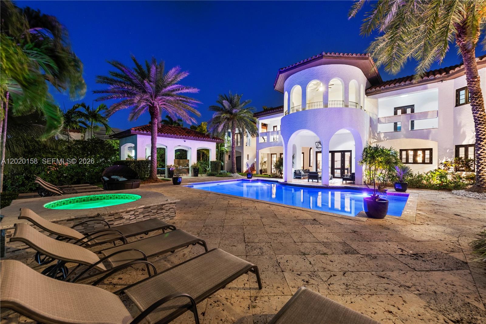 A two-story Mediterranean-style home features a swimming pool, hot tub, and patio at night — 1201 NE 83rd St, Miami FL 33138, MIAMI, FL